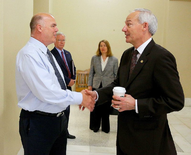 Rep. Joe Jett (left), D-Success, talks with Gov. Asa Hutchinson in the hallway of the state Capitol on Thursday as action at the special legislative session winds to a close. 