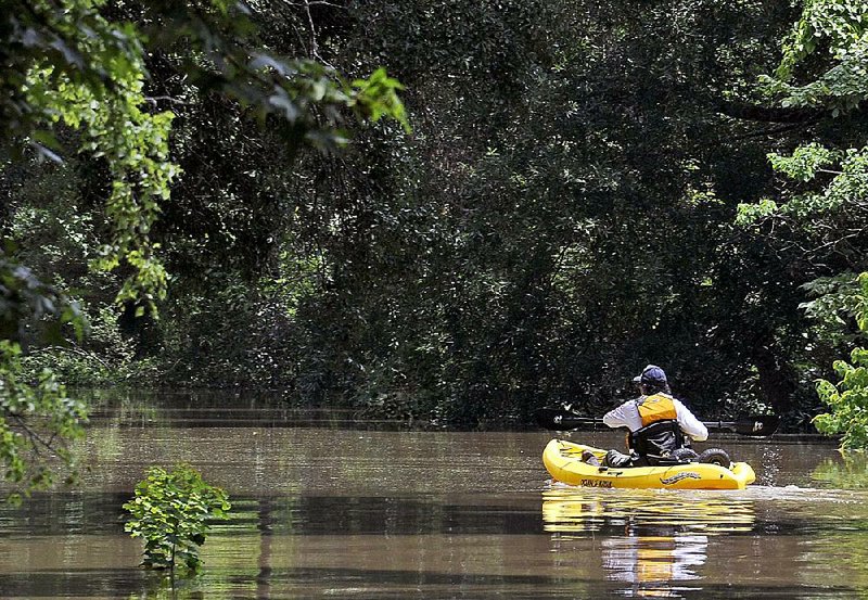 Floodwater from the rising San Jacinto River provides a watery route Thursday through a park in Kingwood, Texas. 