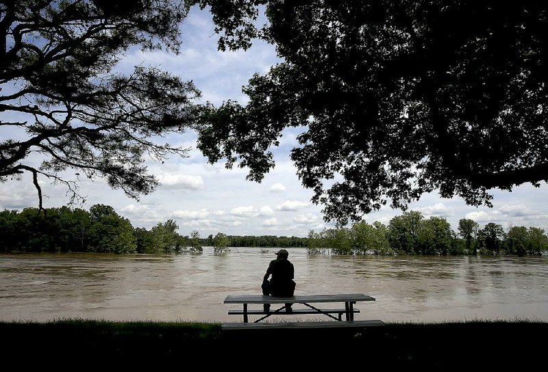 A visitor to Maumelle Park keeps watch on the Arkansas River as the water continues to rise Thursday. 