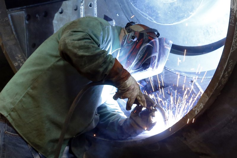 In this photo made on Thursday, Feb. 12, 2015, a man welds parts in fans for industrial ventilation systems at the Robinson Fans Inc. plant in Harmony, Pa. On Friday, the government will likely say the economy shrank in the January-March quarter for a second straight year, but steady job gains are widely expected to propel modestly healthy growth for the rest of 2015.