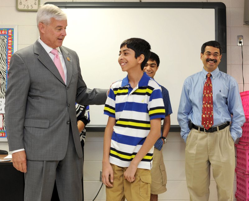 U.S. Rep. Steve Womack (left), R-Rogers, presents an award Friday to Sojas Wagle, a student at Southwest Junior High School, in recognition of his third-place finish in the National Geographic Bee during a surprise visit to the Springdale school. Sojas is standing with his mother, Aparna, father Sameer, and brother Saurabh.