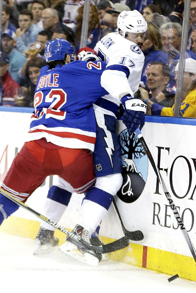 New York Rangers defenseman Dan Boyle (left) crashes Tampa Bay center Alex Killorn into the boards during Game 7 of the NHL Eastern Conference final on Friday.