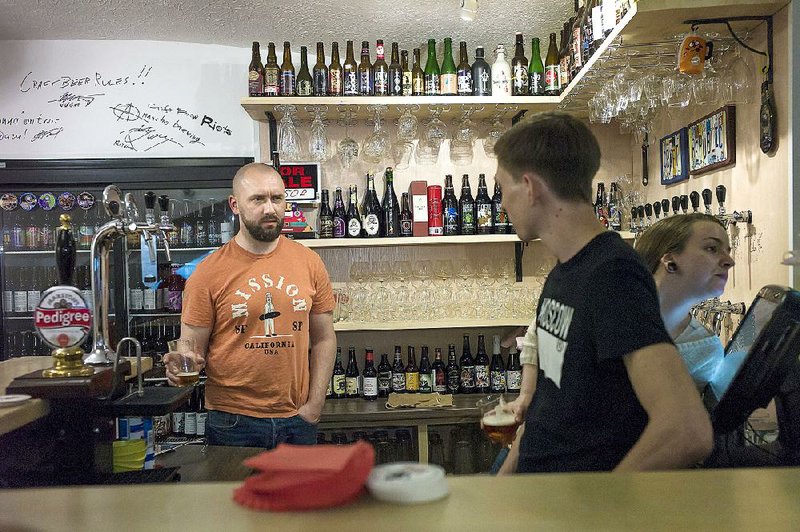 Stanislav Obraztsov (left) speaks to his colleagues at his craft beer bar in Moscow. The ruble’s crash in value against the dollar last year helped Russia’s nascent craft beer industry by making imported brews more expensive. 
