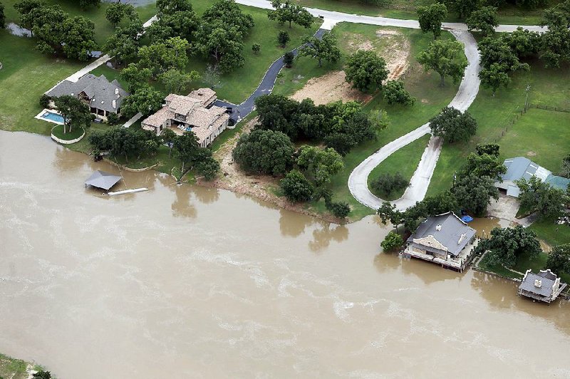 Floodwaters from the Brazos River advance on homes Friday in Weatherford, Texas, after the river, which had been receding, began to rise again.