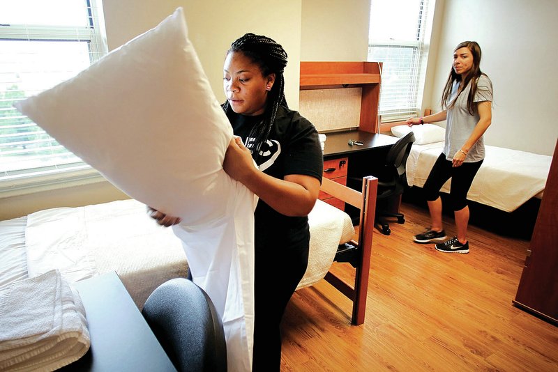 NWA Democrat-Gazette/DAVID GOTTSCHALK Brooke Murphy (left) and Alexa Wimberly, both with University of Arkansas Summer Conferences, leave fresh linens and towels in one of the rooms in Maple Hill South Friday on the campus in Fayetteville. The University of Arkansas and Wal-Mart Stores Inc. signed a new contract to cover facilities and services during shareholder week. Wal-Mart&#8217;s international and domestic employees will fill about 5,000 rooms on campus during the week and and the university&#8217;s conference services staff are making final checks before the first international visitors arrive.