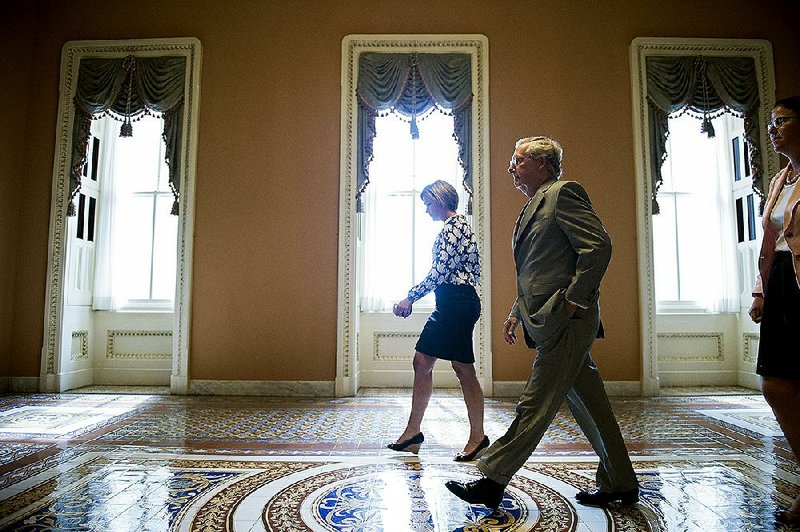 Senate Majority Leader Mitch McConnell walks from the Senate chamber after gaveling open a special session Sunday to extend surveillance programs. 