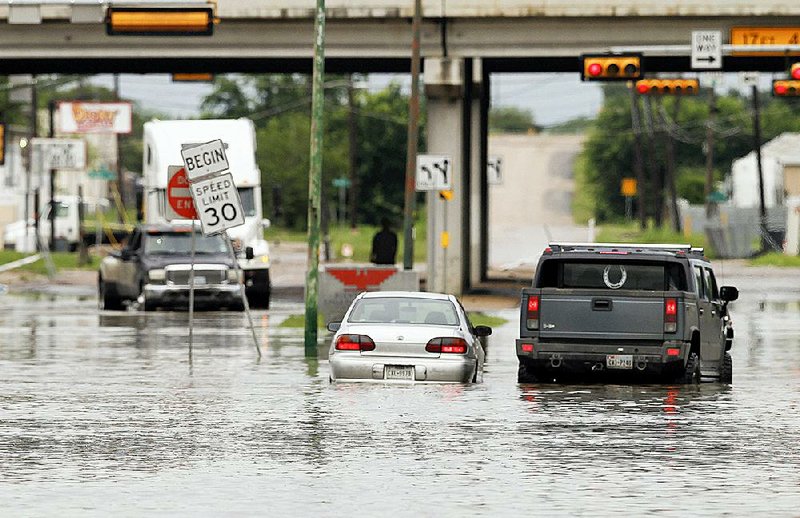 A motorist stops to help another driver stranded in high water Saturday in Dallas. Parts of Texas were finally beginning to see relief Sunday from rain and flooding. 