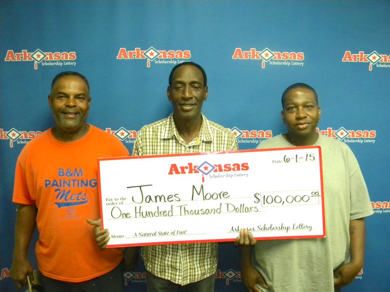 James Moore of Camden, along with his nephew Mark and cousin Jeff, collects his $100,000 prize from the Arkansas Scholarship Lottery on Monday, June 1, 2015. 