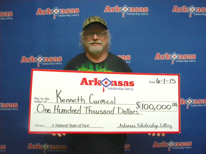 Kenneth Carmical of Rogers on Monday, June 1, 2015, displays his $100,000 winnings from the Arkansas Scholarship Lottery. 