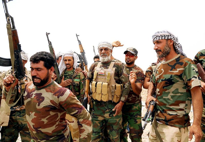 Badr Brigades Shiite militia fighters chant slogans against the Islamic State group at the front line Monday on the outskirts of Fallujah, Anbar province, Iraq. 