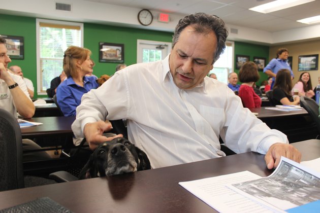 Bernard Major, an adjuster with Affirmative Risk Management in Little Rock, pets Harley Pollack, the firm's dog vice president of marketing and public relations.