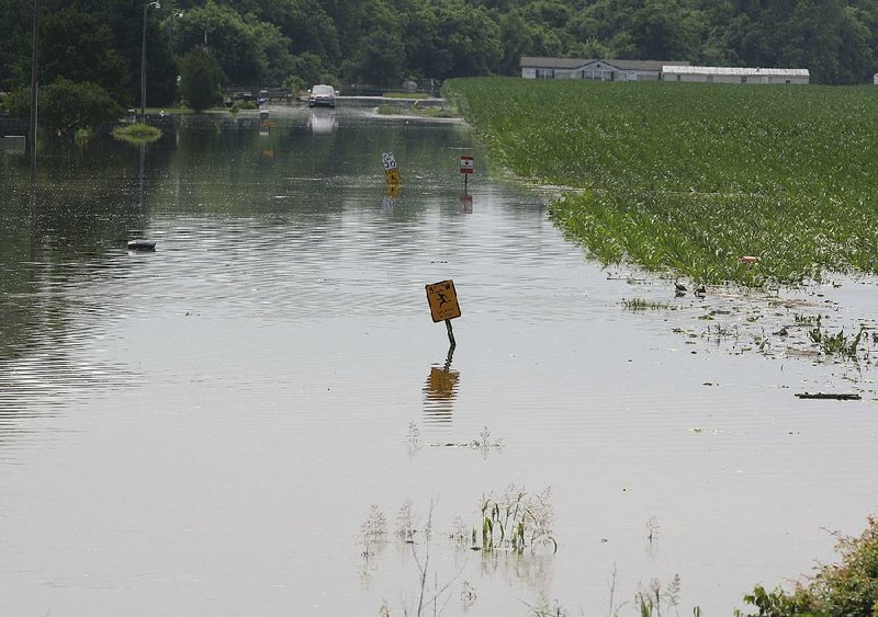 Water covers Riviera Drive in Pine Bluff on Tuesday. Several people have chosen to stay in their homes there, officials said. Wesley Hunt, a member of the Jefferson County Office of Emergency Management, warned residents to be on the lookout for snakes. “We’re urging those who are staying in their homes to watch out for them.” he said. “This is the time for them. The flooding has brought them out.”