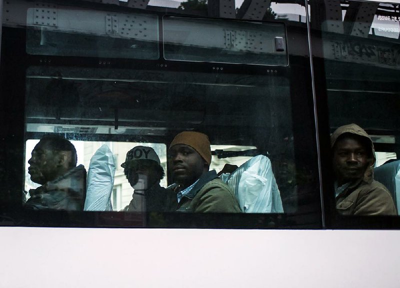 People are evacuated by bus from a tent camp in Paris on Tuesday.