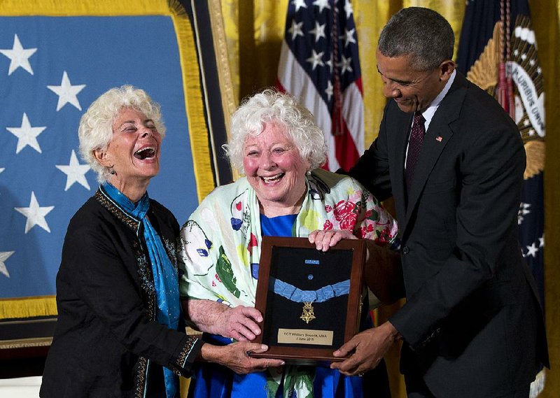 President Barack Obama posthumously presents the Medal Of Honor for Army Sgt. William Shemin to his daughters Ina Bass (left) and Elsie Shemin-Roth, of suburban St. Louis, during a ceremony Tuesday in the East Room of the White House in Washington.