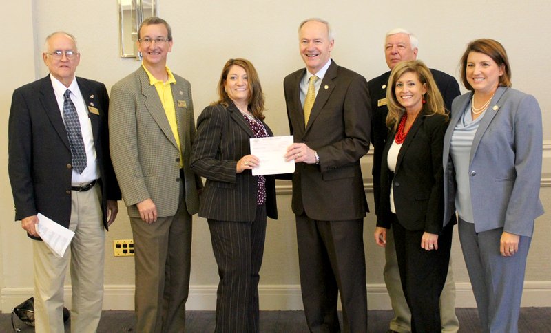 Submitted Photo With the grant check for Highfill are ARDC commissioner Lonnie Turner, ARDC commissioner James Myatt, grant writer Cassie Eilliot, Governor Asa Hutchinson, ARDC chair Glenn Priebe, AEDC deputy director Amy Fecher, ARDC commissioner Jamie Pafford-Gresham. Not pictured are Senator Bart Hester and Representative Dan Douglas.