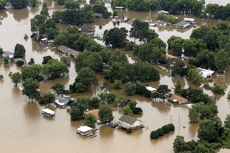 Floodwaters from the Arkansas River overtake homes Wednesday in Pine Bluff. The Arkansas River was forecast to crest at 4 feet above flood stage overnight in Pine Bluff.
