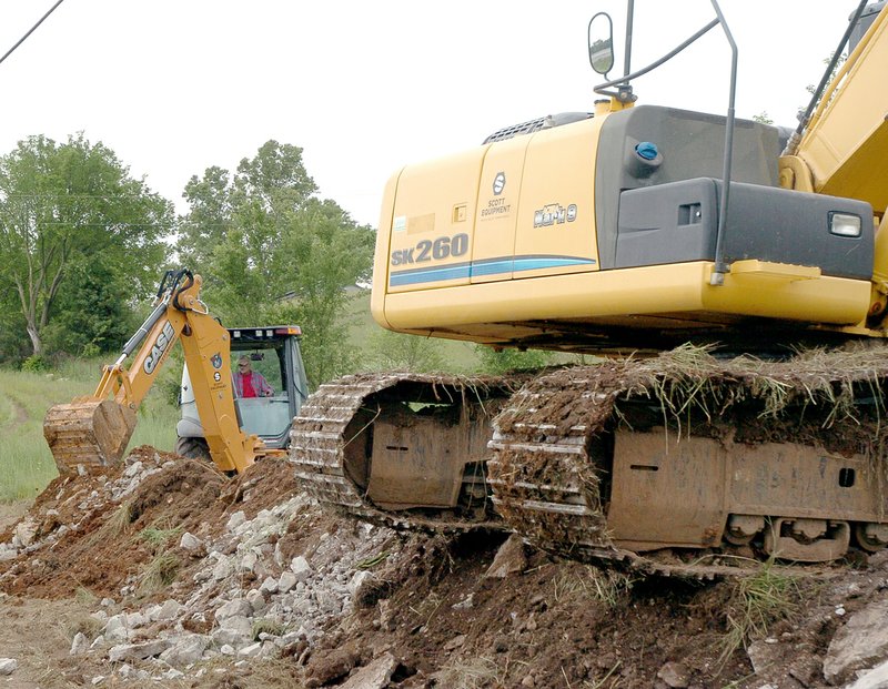 RICK PECK MCDONALD COUNTY PRESS Buddy Townsend, of R and R Construction of Bentonville, Ark., cleans out rock from a ditch for the installation of a new water line as part of a $5.5 million water system improvement project approved in April by voters of the Public Water Supply District No. 1.