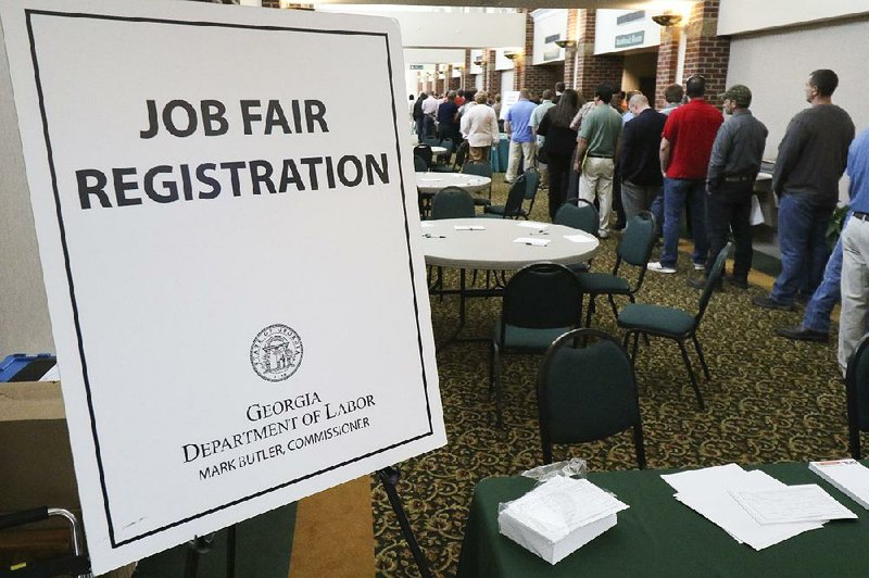 Job seekers line up at a job fair at The Colonnade in Ringgold, Ga., in April. Applications for unemployment aid dropped 8,000 last week to a seasonally adjusted 276,000, the Labor Department said.