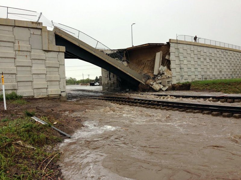 This photo provided by the Wyoming Highway Patrol shows a portion of a bridge over railroad tracks on the north side of the small eastern Wyoming town of Lusk that was collapsed by flash flood waters early Thursday. June 4, 2015. Up to 6 inches of rain fell in the area overnight Wednesday and early Thursday, forcing some residents to leave their homes and causing damage to area highways.