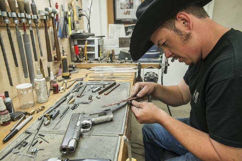 FILE PHOTO: Allen Wyatt, a gunsmith at Nighthawk Custom, works on the trigger mechanism of a pistol in 2015.