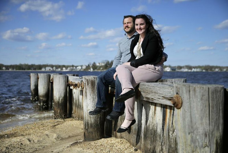 Kate MacHugh and fiance C.J. (Christopher John) Ecke sit together on a seawall in Pine Beach, N.J., on April 24. “When I was a little girl I always envisioned it as ‘my wedding,’ where I would make all the decisions and my faceless groom would show up when I told him to in the suit that I picked out and he paid for,” said the Beachwood, N.J., social worker and bride-to-be. The couple are getting hitched Oct. 10. 