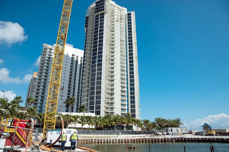A construction crane stands next to the Porsche Design Tower in Miami Beach, Fla., in February. Downtown Miami’s luxury-condo boom is suffering from the year-long climb in the U.S. dollar. 
