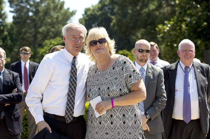Colleen Nick hugs Gov. Asa Hutchinson after speaking at a Capitol news conference Friday in honor of her daughter, Morgan Nick. Morgan disappeared from an Alma ballpark 20 years ago when she was 6.
story.lead_photo.caption