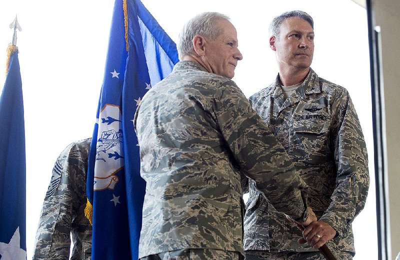 Brig. Gen. James K. Vogel (right) assumes command of the Arkansas Air National Guard in a ceremony Saturday. Handing the Air National Guard colors to transfer command is Brig. Gen. Travis D. Balch, who retired Friday.