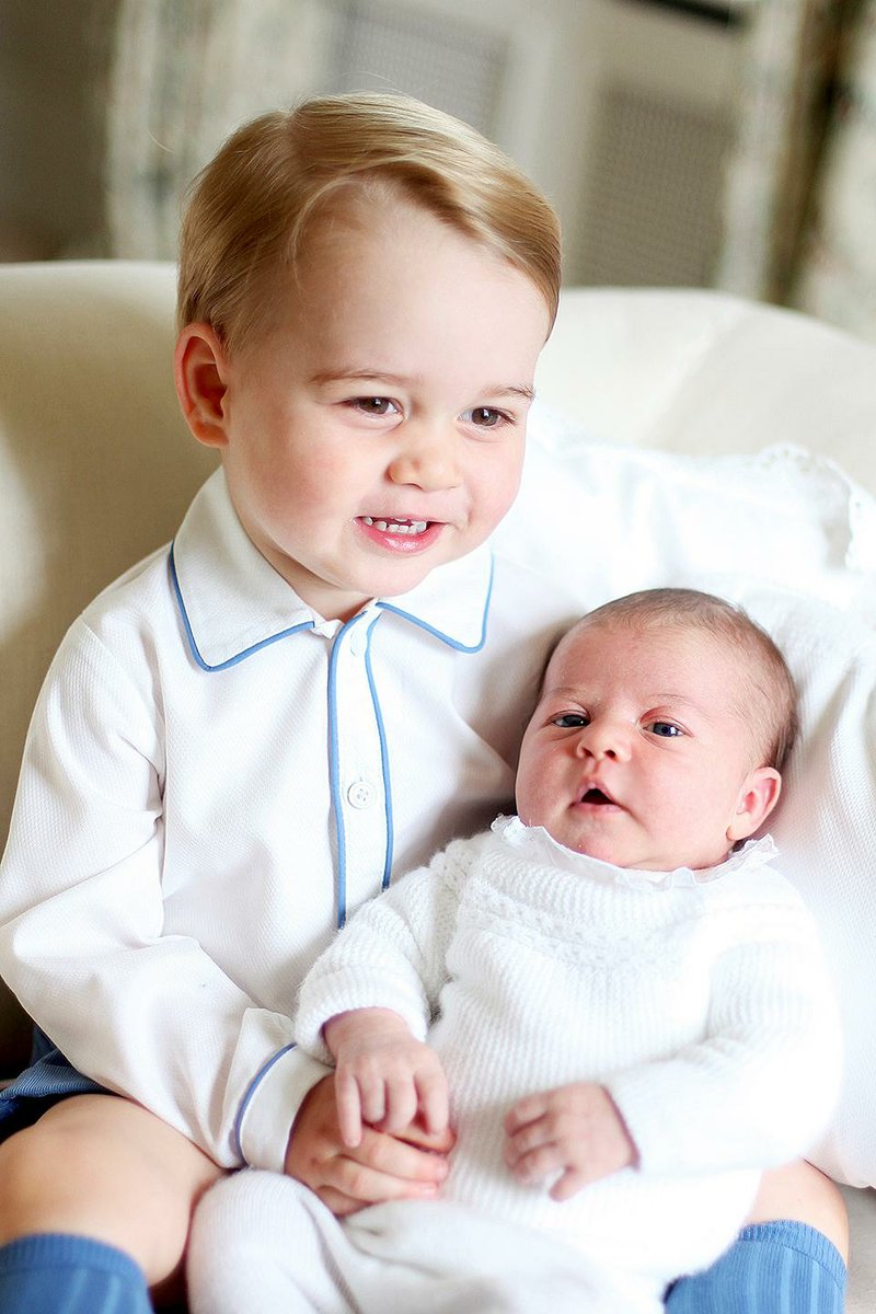 Britain's Princess Charlotte, right, being held by her brother, 2-year-old, Prince George. Charlotte was born May 2 and is fourth in line to the throne. 