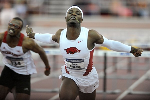 Omar McLeod (right) of Arkansas finishes ahead of Oladapo Akinmoladur (left) of Nebraska in the 60-meter hurdles Saturday, March 14, 2015, in the NCAA Indoor Track and Field Championship at the Randal Tyson Track Center in Fayetteville.