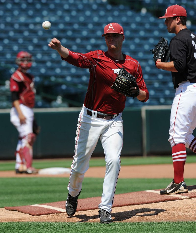 Arkansas pitcher Trey Killian throws to first Thursday, June 4, 2015, during pitchers fielding practice at Baum Stadium in Fayetteville.
