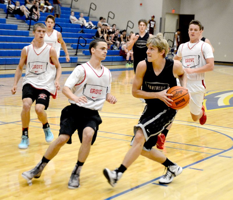 Graham Thomas/Herald-Leader Rising senior Caleb Lampton drives to the basket against Grove, Okla., last week as the Siloam Springs boys basketball team competed at Golden Eagle Team Camp at John Brown University.