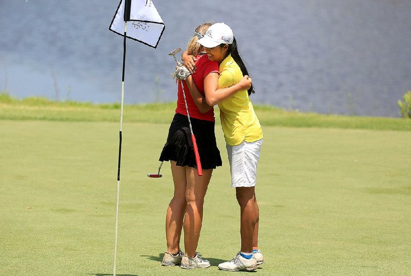 Allie Weiner and Elizabeth Moon (right) embrace after finishing Wednesday’s final round in the ASGA Bruce Jenkins Memorial at Rebsamen Golf Course in Little Rock. Both Weiner and Moon shot a fi nal-round 77, but Moon won the girls title while Weiner finished third.