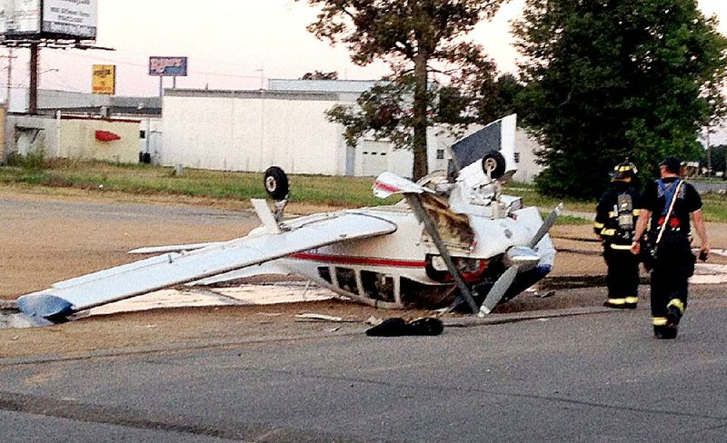 Jonesboro firefighters examine a small plane after it crash-landed in a parking lot early Wednesday. 