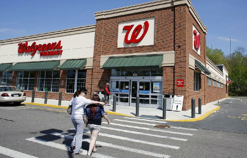 Customers approach a Walgreens store in Boston in this file photo. Walgreens said Wednesday that it will offer a smartphone application that links doctors and patients in 25 states by the end of the year. 
