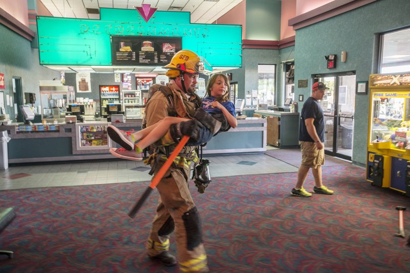 NWA Democrat-Gazette/ANTHONY REYES &#8226; @NWATONYR A Springdale firefirghter carries away a &#8220;patient&#8221; in a mass-casualty drill Wednesday at the Springdale Malco Theater on Sunset Avenue. Several area fire departments participated, including Fayetteville, Rogers, Northwest Arkansas Regional Airport and Eureka Springs. More than 30 volunteers played victims in a simulated fire. For photo galleries, go to nwadg.com/photos.