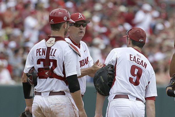 Arkansas coach Dave Van Horn, center, talks to catcher Tucker Pennell (27) and first baseman Clark Eagan (9) during the second inning in a super regional of the NCAA college baseball tournament game against Missouri State in Fayetteville, Ark., Saturday, June 6, 2015. (AP Photo/Danny Johnston)