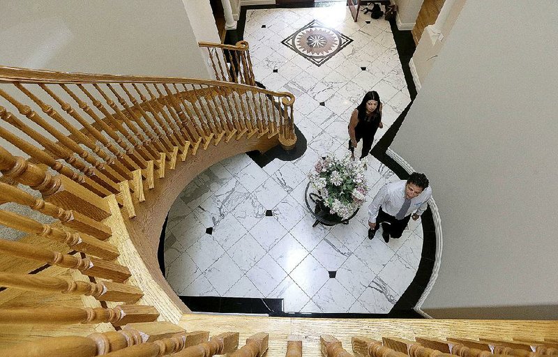 Realtor Stephan Marshall (bottom), walks with client Sasha Martinez at a house for sale in Pacifica, Calif. A rising stock market and climbing home prices drove Americans’ net worth higher in the first three months of the year. 