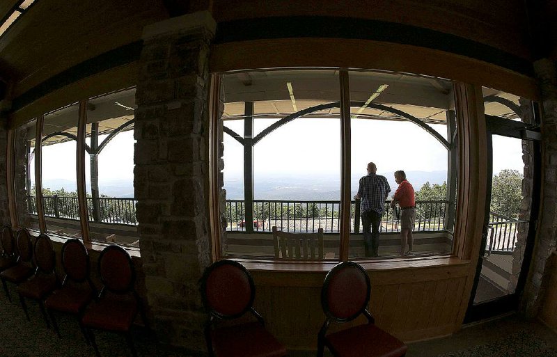 Members of the state Parks, Recreation and Travel Commission, Jim Shamburger (left) and Bill Barnes, check out the view from new, wider windows Thursday at the Queen Wilhelmina State Park Lodge near Mena.