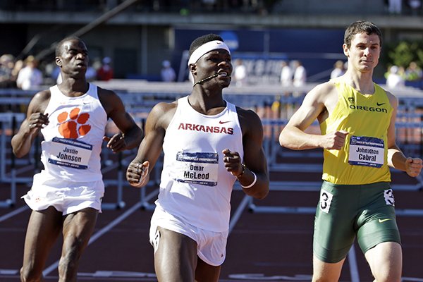 Arkansas's Omar McLeod, middle wins the 110-meter hurdles ahead of Clemson's Justin Johnson, left, and Oregon's Johnathan Cabral during the NCAA track and field championships in Eugene, Ore., Friday, June 12, 2015. Johnson finished seventh while Cabral took second. (AP Photo/Don Ryan)