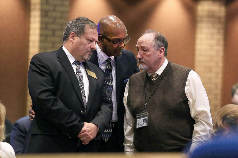 T.C. Wallace (center), interim Pine Bluff school superintendent, talks with Elbert Harvey (left) and Richard Wilde of the state Department of Education’s school improvement office Friday during a meeting in Little Rock on academically troubled schools in Pine Bluff.