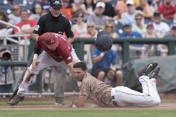 Virginia's Daniel Pinero steals third base while Arkansas' Bobby Wernes tries to make the tag in the 8th inning Saturday, June 13, 2015 during game one of the College World Series at TD Ameritrade Park in Omaha. Arkansas lost 5-3.