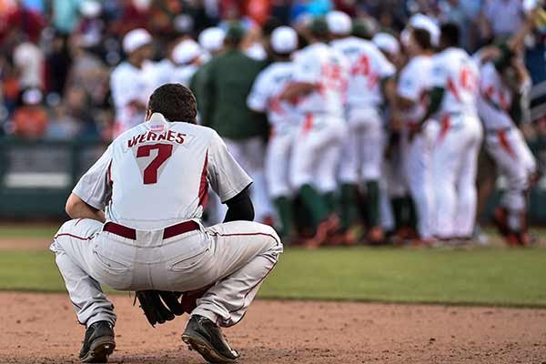 Arkansas third baseman Bobby Wernes (7) watches Miami players celebrate the team's 4-3 win in an NCAA College World Series baseball elimination game in Omaha, Neb., Monday, June 15, 2015. (AP Photo/Mike Theiler)