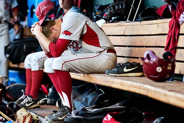 Arkansas' Zach Jackson sits in the dugout after Miami's 4-3 win in an NCAA college baseball game in the College World Series, Monday, June 15, 2015, in Omaha, Neb. (Chris Machian/The Omaha World-Herald via AP)