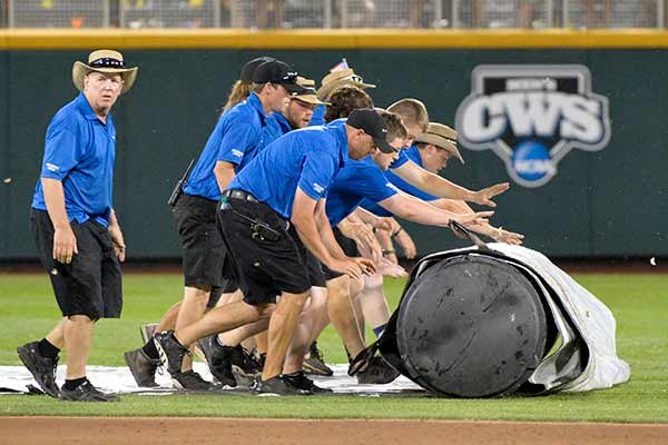 Grounds keepers roll out the tarp during a rain delay in the sixth inning of an NCAA College World Series baseball game between Cal State Fullerton and Vanderbilt, at TD Ameritrade Park in Omaha, Neb., Sunday, June 14, 2015. (AP Photo/Ted Kirk)