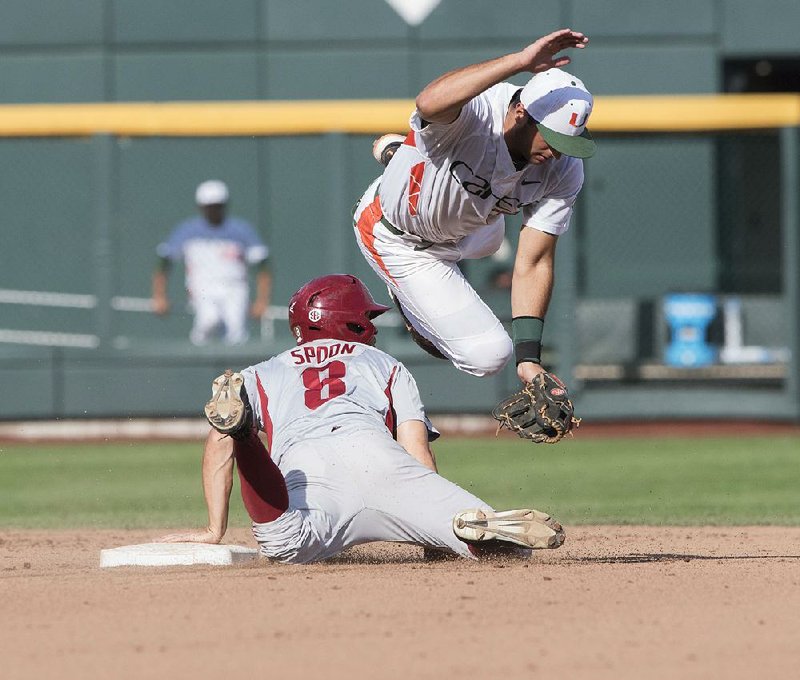 Arkansas’ Tyler Spoon (8) steals second base while Miami’s George Iskenderian tries to apply the tag during Monday’s game. The Razorbacks stranded 11 runners despite outhitting Miami 9-7.