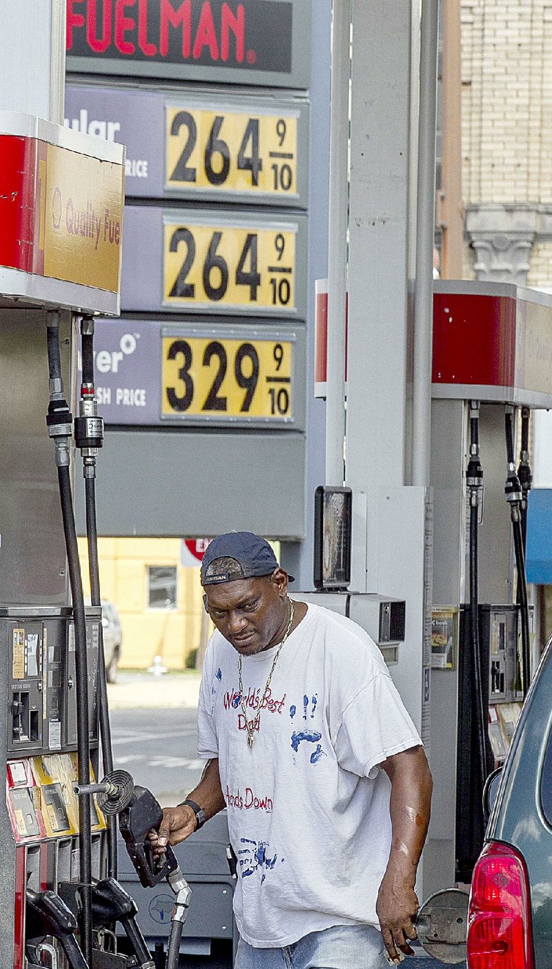 A motorist gasses up Monday at a Shell station at West Eighth Street and Broadway in Little Rock. 