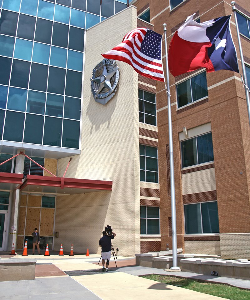 Boarded up windows beside the entrance to the Jack Evans Police Headquarters on S. Lamar provide the backdrop for  a television news segment in Dallas, Sunday, June 14, 2015. James Boulware, the man linked to a violent assault on Dallas police headquarters was accused two years earlier of choking his mother, then fleeing to an East Texas town where schools were locked down out of fear he would attack them as "soft targets," according to accounts from police and family members.