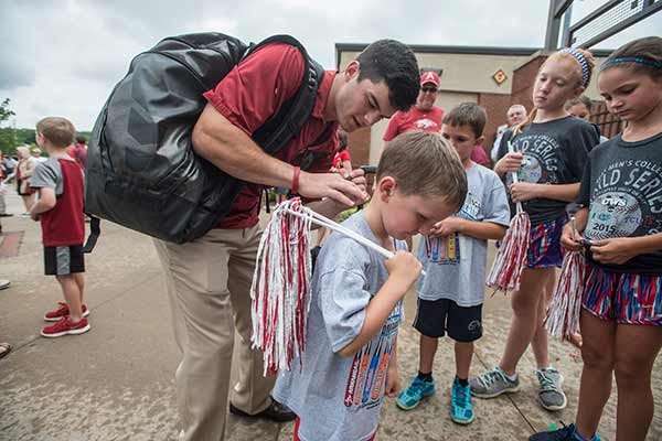 Andrew Benitendi, outfielder for the University of Arkansas baseball team, signs a shirt for pint sized fan Brooks Bohannon, 6, Tuesday, June 16, 2015, at Baum Stadium in Fayetteville. Fans welcomed back members of the team as they returned from playing in the College World Series in Omaha, Neb.