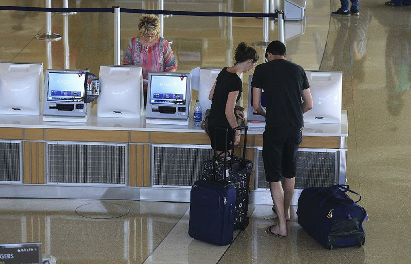Passengers check in Tuesday afternoon for a flight at Bill and Hillary Clinton National Airport/Adams Field, where boardings and arrivals continued to decline. 